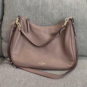 Mauve colored Kate Spade bag with crossbody strap.